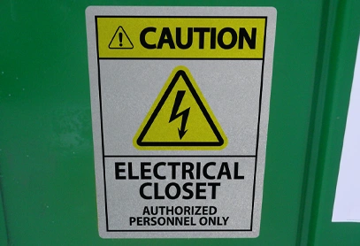 Caution sign reading Electrical Closet – Authorized Personnel Only with a high-voltage symbol, mounted on a green surface for safety compliance.